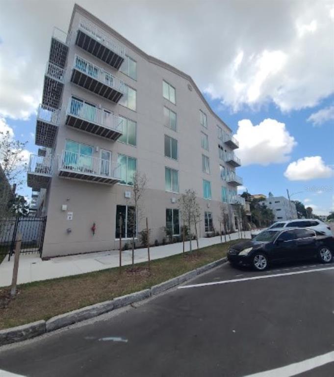 A multi-story apartment building with balconies and a parking lot in the foreground — 644 3RD AVENUE S UNIT 408, ST PETERSBURG, FL