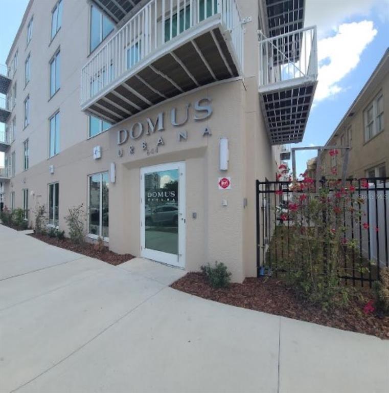 The exterior of a multi-story apartment building with a glass entrance door and metal balconies — 644 3RD AVENUE S UNIT 408, ST PETERSBURG, FL