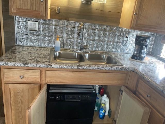 A stainless steel refrigerator stands next to a stacked washer and dryer in a kitchen — 800 32ND AVENUE S UNIT 227, ST PETERSBURG, FL