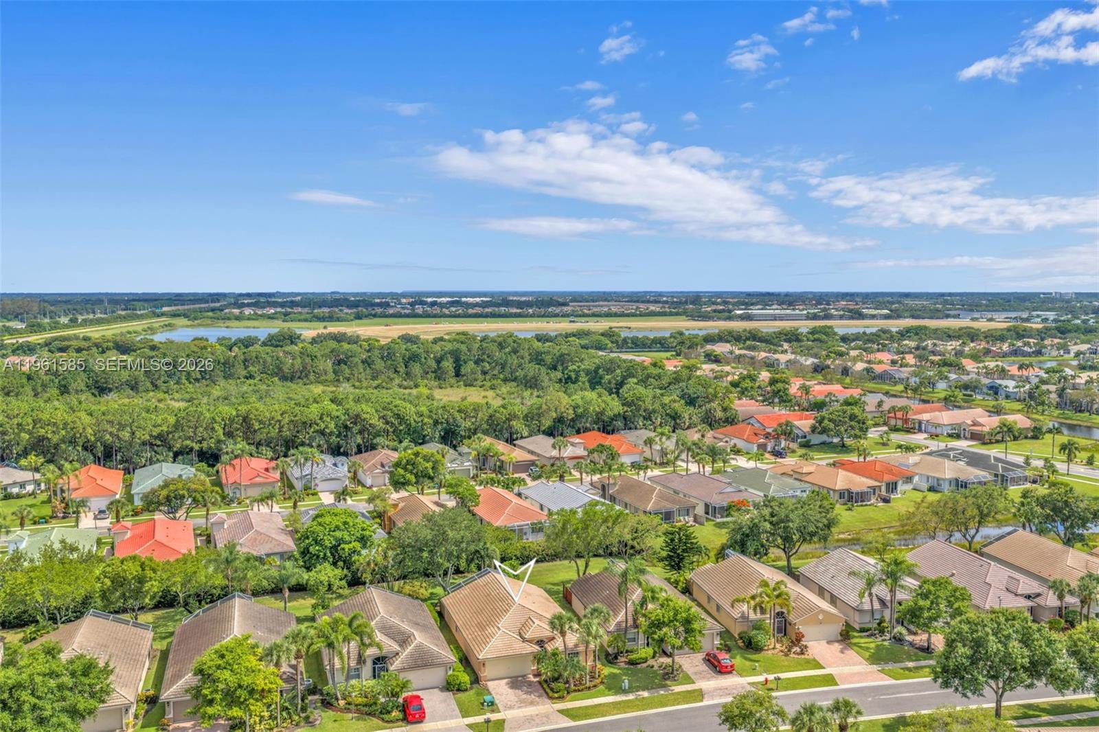An aerial view shows a suburban neighborhood with single-family homes and a large green space — 8046 Duomo Cir, Boynton Beach FL 33472, BOYNTON BEACH, FL