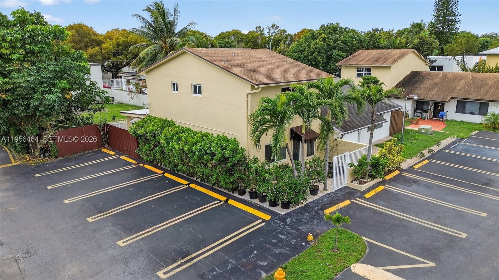 An aerial view shows a two-story yellow building with a parking lot and landscaping — 2455 SW 11th St # A, Miami FL 33135, MIAMI, FL