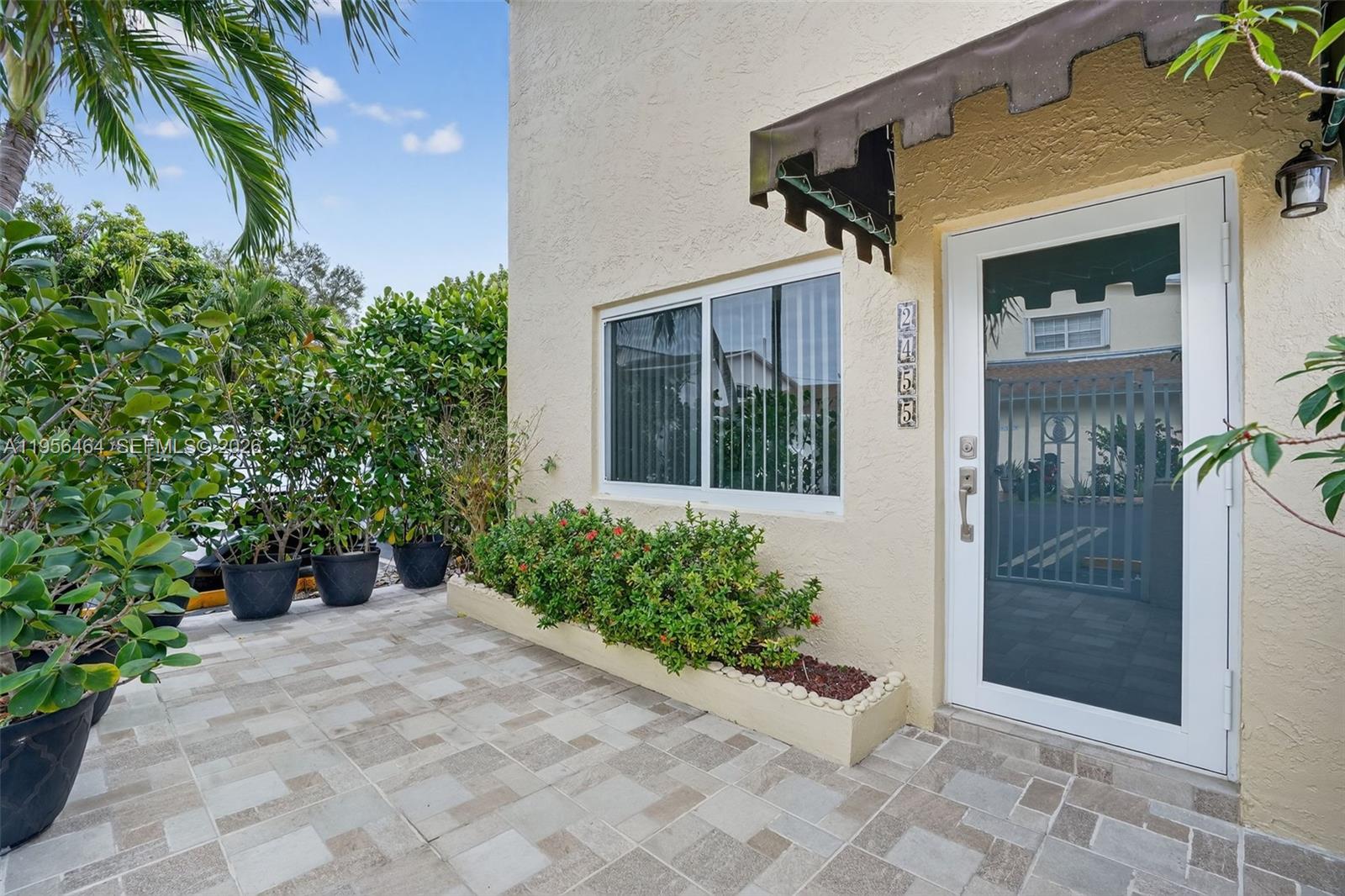 An exterior view of a building entrance with a tiled patio and potted plants — 2455 SW 11th St # A, Miami FL 33135, MIAMI, FL