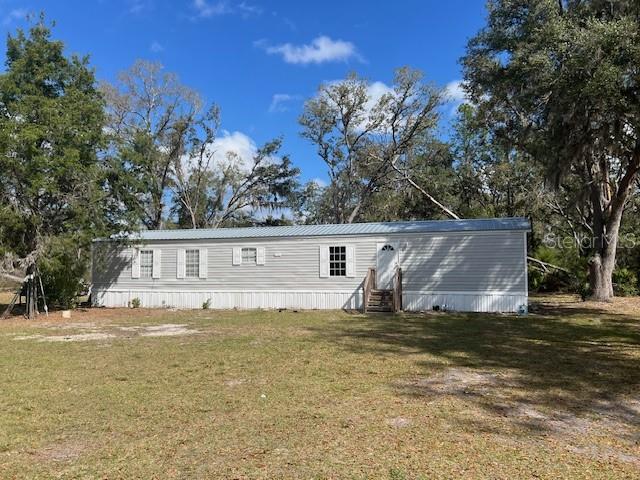 A single-story manufactured home with light gray siding sits on a grassy lot — 65 SE 153 AVENUE, OLD TOWN, FL