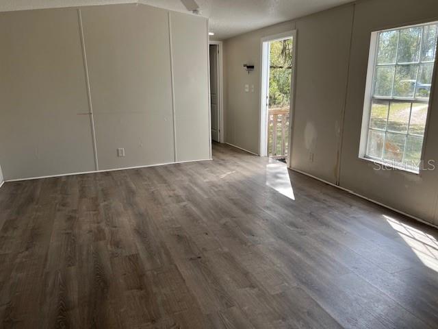An interior view of a room with light-colored walls, wood-look flooring, and a glass door — 65 SE 153 AVENUE, OLD TOWN, FL