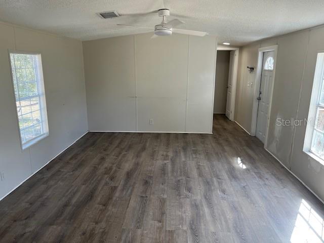 An empty room features light-colored walls, a ceiling fan, and wood-look laminate flooring — 65 SE 153 AVENUE, OLD TOWN, FL