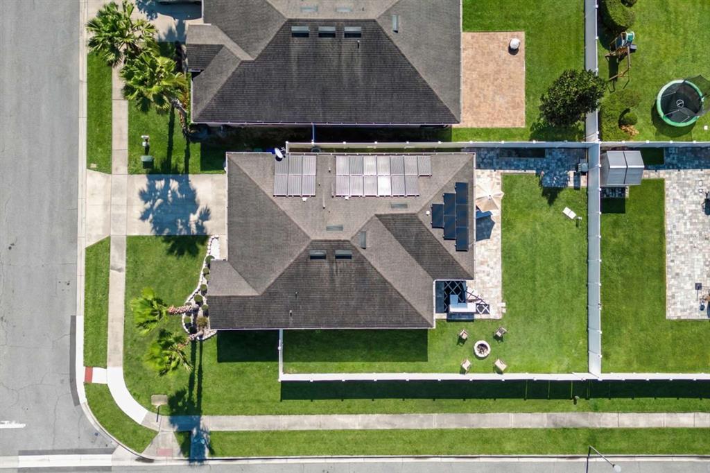 An aerial view shows a house with solar panels on the roof and a backyard — 10502 BULL GRASS DRIVE, ORLANDO, FL