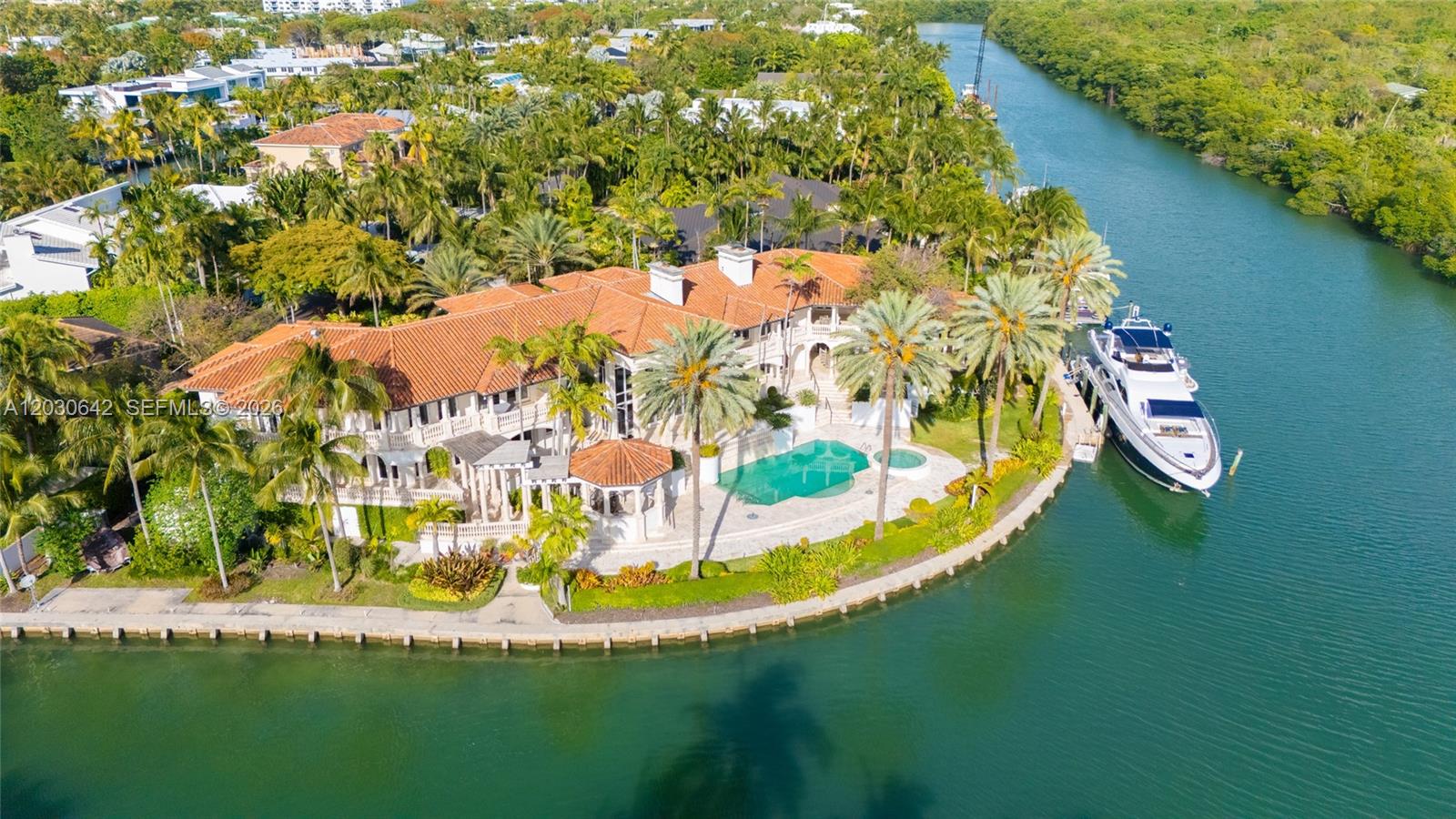 An aerial view shows a large waterfront mansion with a tile roof, pool, and yacht — 260 Cape Florida Dr, Key Biscayne FL 33149, KEY BISCAYNE, FL