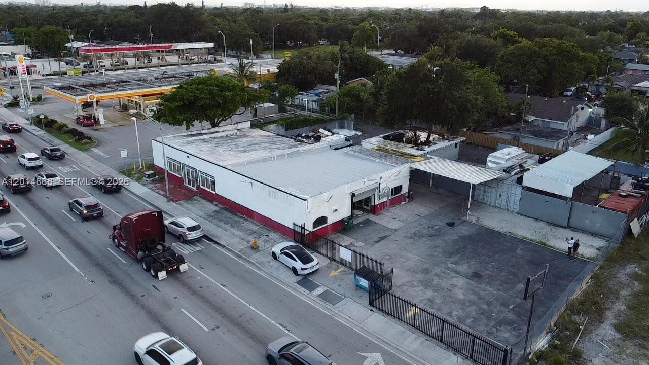 An aerial view shows a commercial building with a red and white exterior near a gas station — 10342 NW 27th Ave, Miami FL 33147, MIAMI, FL