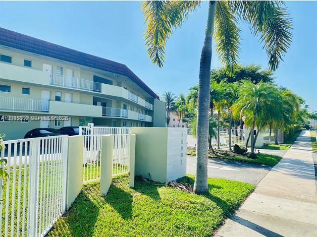 A multi-story apartment building stands next to a sidewalk and palm trees — 18901 NE 14th Ave # 101, Miami FL 33179, MIAMI, FL