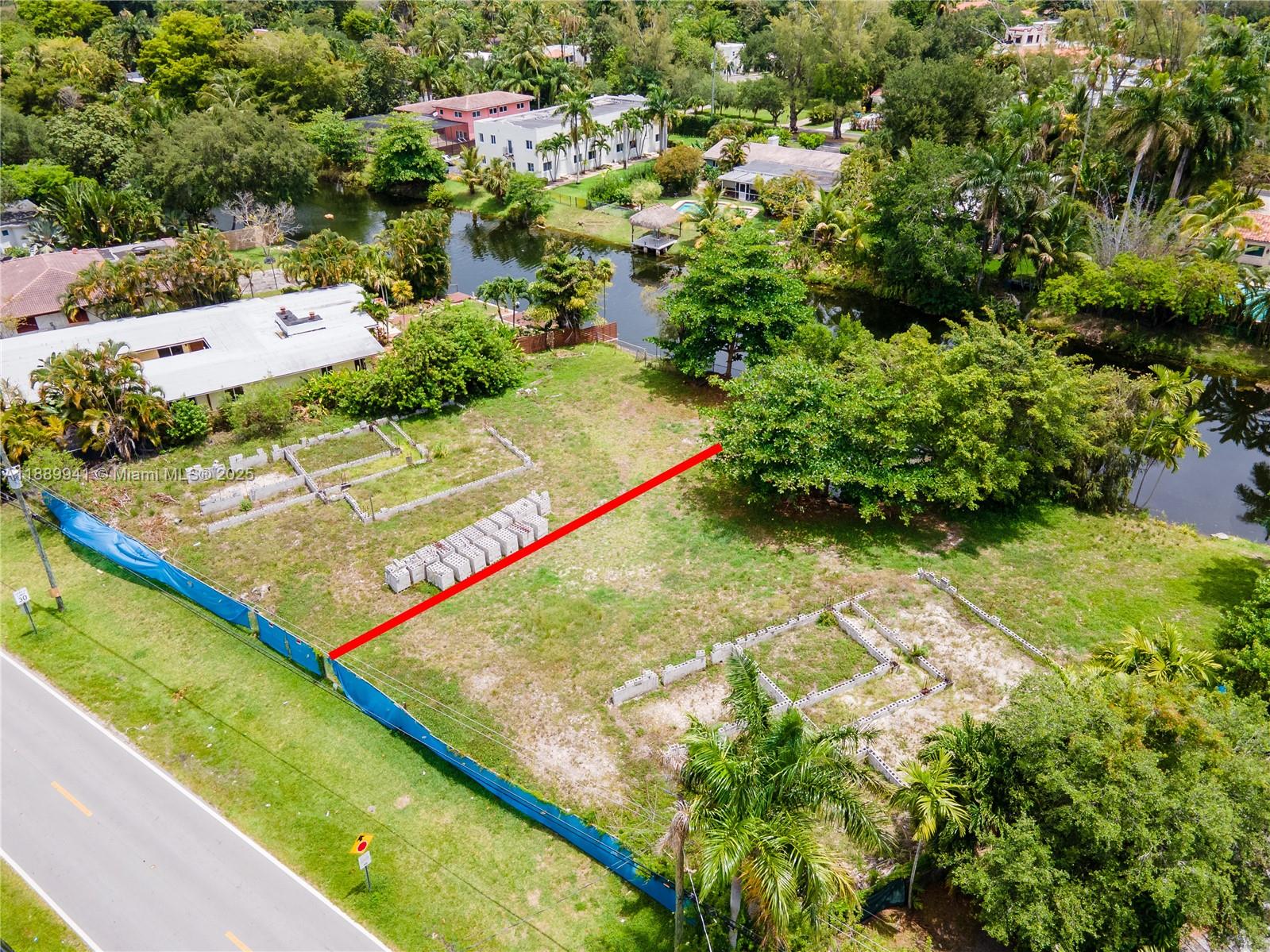 An aerial view shows a vacant residential lot with concrete foundations and a red boundary line — 11595 W Biscayne Canal Rd, Miami FL 33161, MIAMI, FL