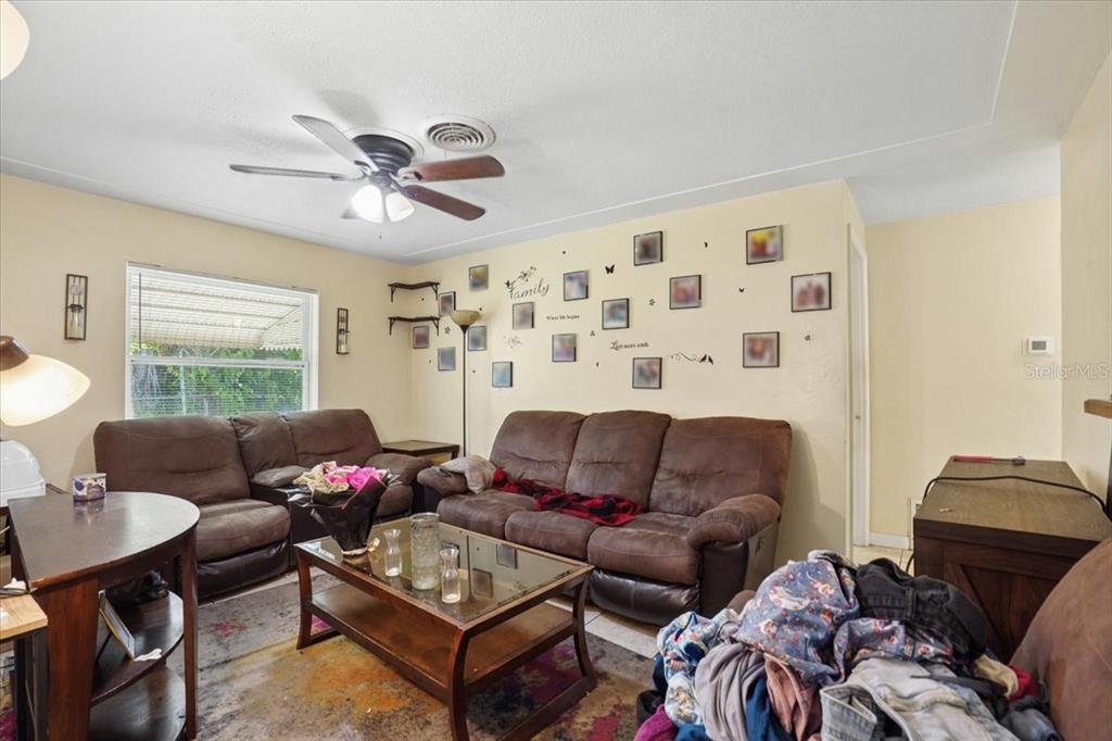 A living room features brown sofas, a glass-top coffee table, and a wall gallery — 526 12TH AVENUE S, ST PETERSBURG, FL
