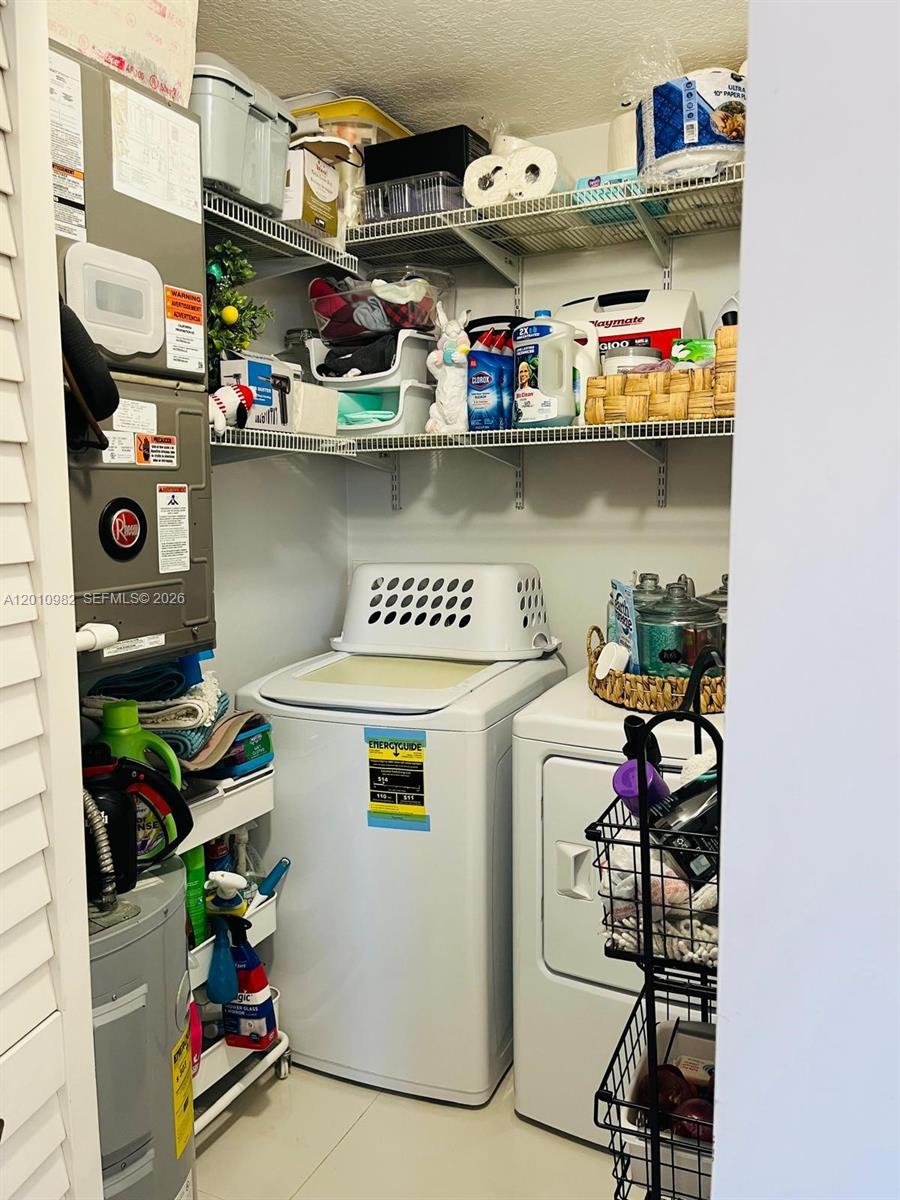A laundry closet contains a white washer and dryer with wire shelving above — 7817 W 36th Ave # 204, Hialeah FL 33018, HIALEAH, FL