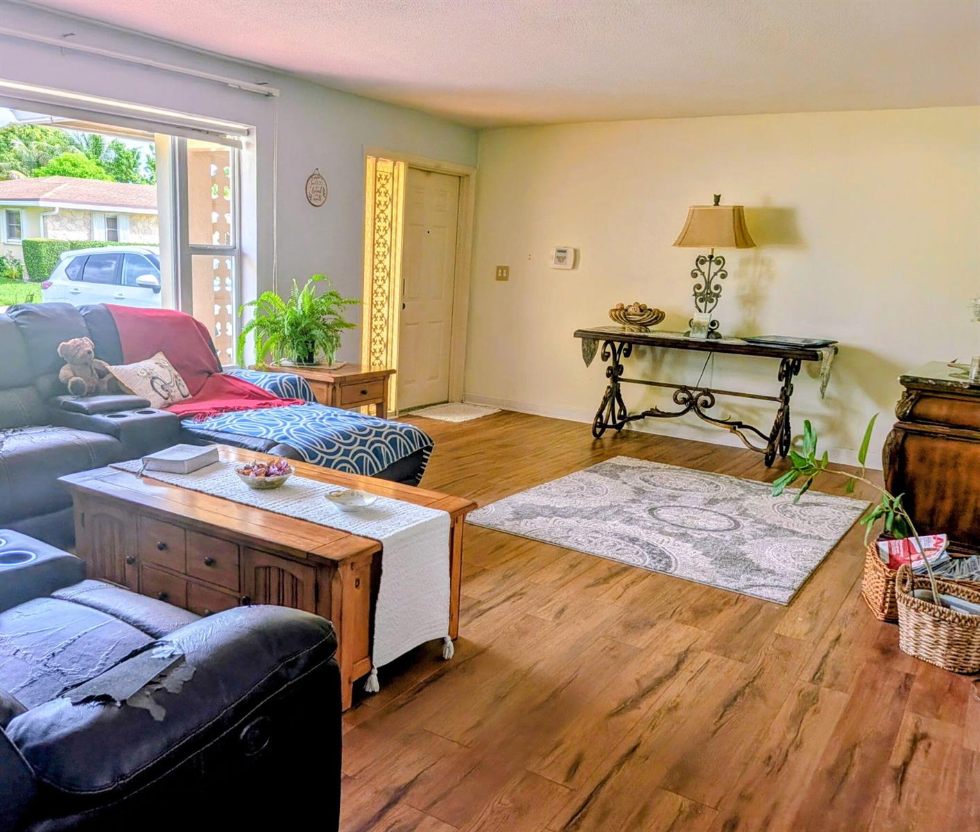A living room features wood-look flooring, a leather sectional, a console table, and a rug — 4914 NW 49th Road, Tamarac FL 33319, TAMARAC, FL