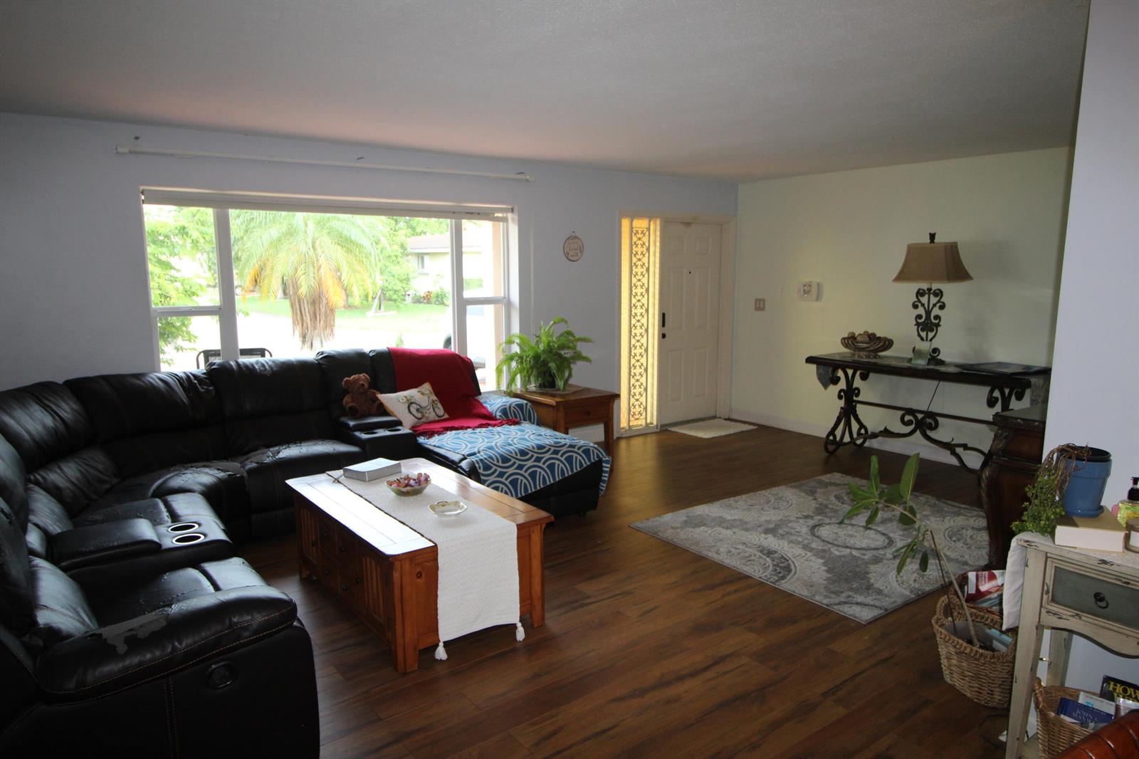 A living room features a black sectional sofa, wood coffee table, and wood-look flooring — 4914 NW 49th Road, Tamarac FL 33319, TAMARAC, FL