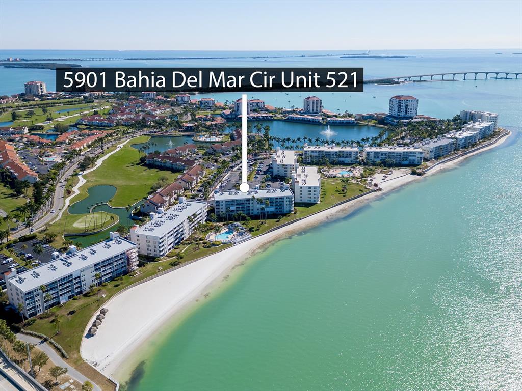 An aerial view shows a multi-story residential building complex situated along a sandy beach — 5901 BAHIA DEL MAR CIRCLE UNIT 521, ST PETERSBURG, FL
