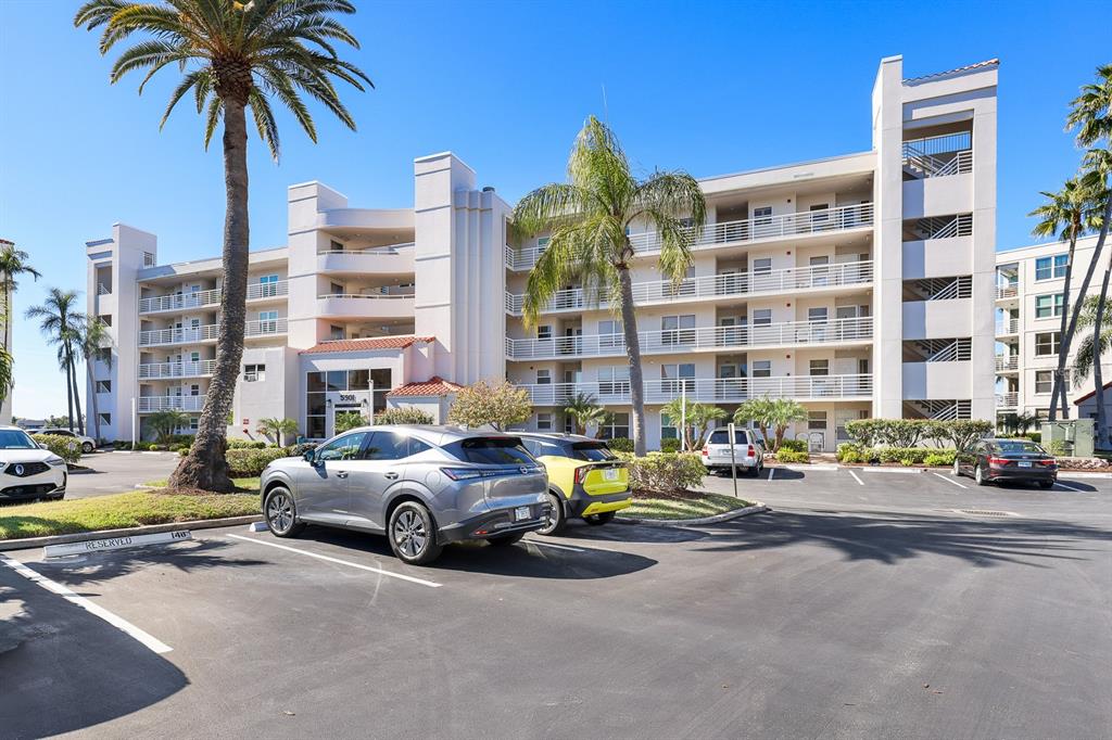 A multi-story apartment building with balconies and a parking lot in the foreground — 5901 BAHIA DEL MAR CIRCLE UNIT 521, ST PETERSBURG, FL
