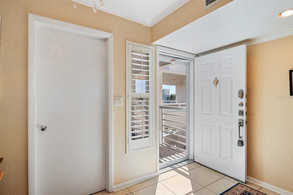 An entryway with a white door, a screen door, and a closed closet door — 5901 BAHIA DEL MAR CIRCLE UNIT 521, ST PETERSBURG, FL
