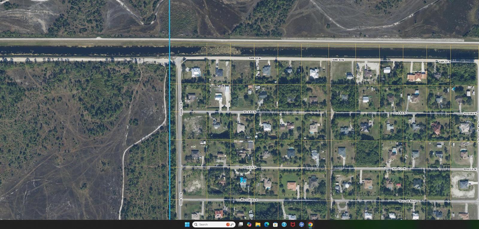 This is an aerial map view of a residential neighborhood with a canal and undeveloped land — 93 Rd Road N, FL 33470, FL