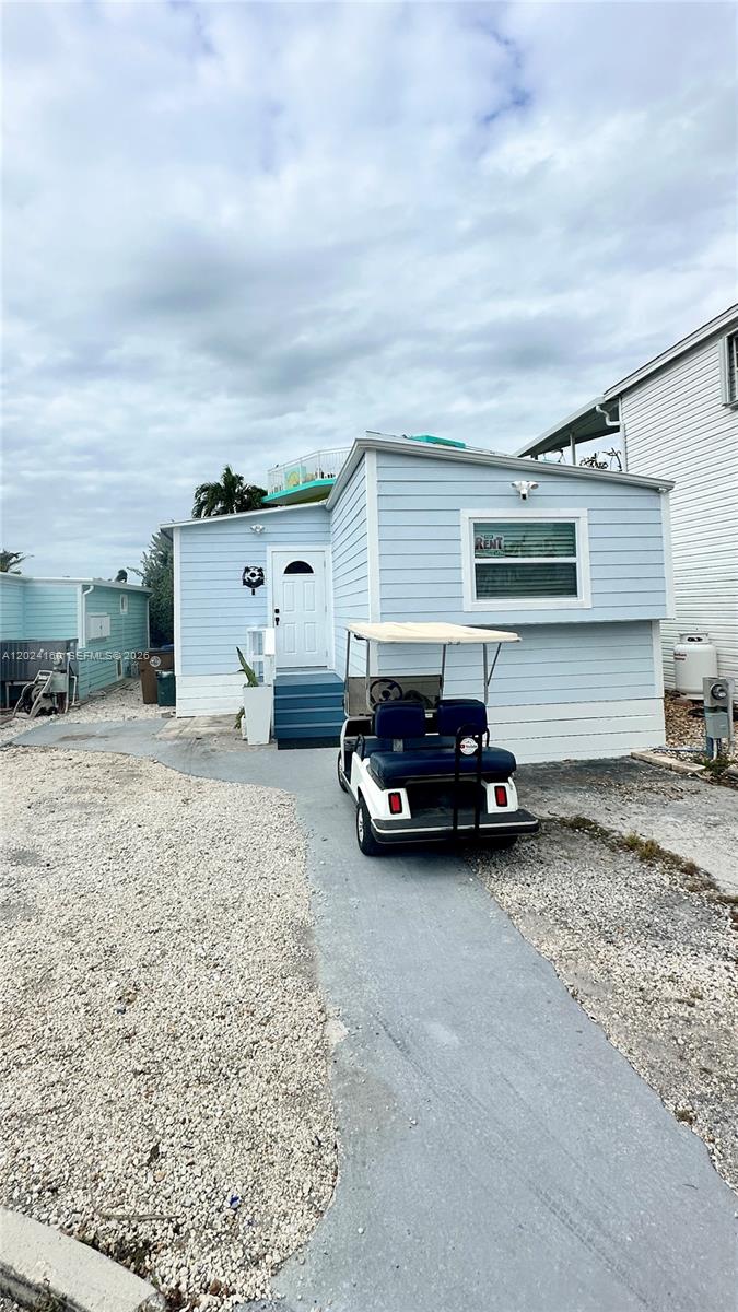 A light blue mobile home with a golf cart parked on a concrete driveway — 65821 Overseas Hwy Unit 314, Long Key FL 33001, LONG KEY, FL