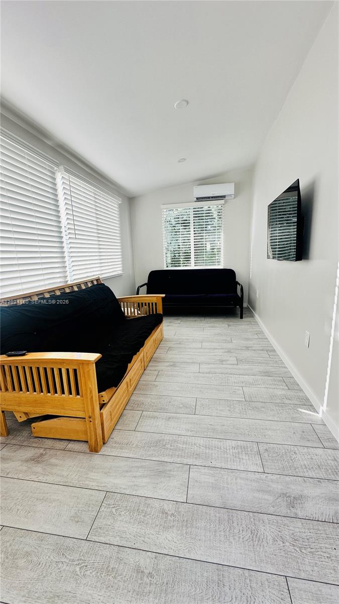 A room with light wood-look tile flooring, two futons, and a wall-mounted television — 65821 Overseas Hwy Unit 314, Long Key FL 33001, LONG KEY, FL