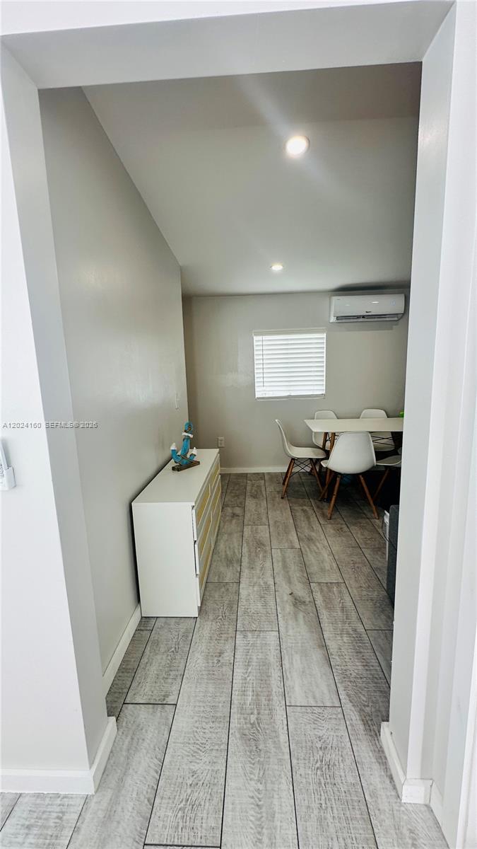 A dining area features wood-look tile flooring, a white dresser, and a wall-mounted air conditioner — 65821 Overseas Hwy Unit 314, Long Key FL 33001, LONG KEY, FL