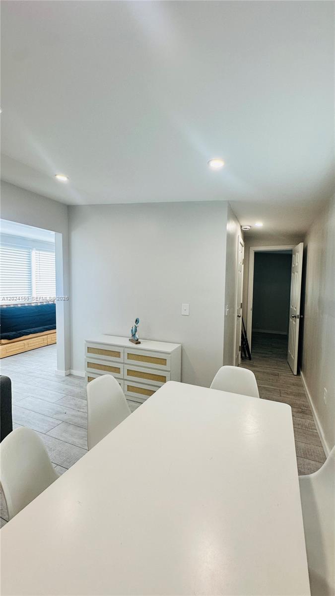 A dining area with a white table and chairs sits near a hallway and dresser — 65821 Overseas Hwy Unit 314, Long Key FL 33001, LONG KEY, FL