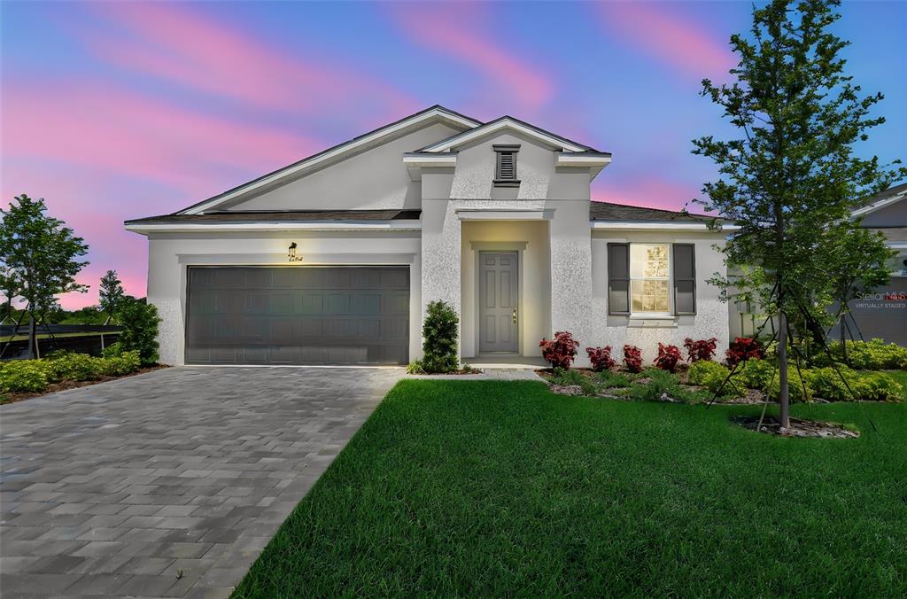 A single-story house with a gray garage door, a paved driveway, and a landscaped front yard — 13494 TURNLEAF BOULEVARD, PUNTA GORDA, FL