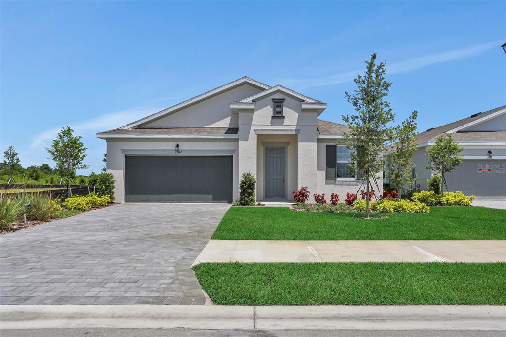 A single-story suburban house with a gray garage, paved driveway, and a small front lawn — 13494 TURNLEAF BOULEVARD, PUNTA GORDA, FL