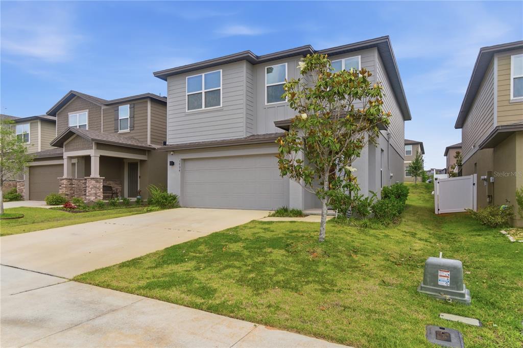 A two-story gray house with a two-car garage and a front yard — 1794 SUNDANCE CHASE ROAD, MINNEOLA, FL
