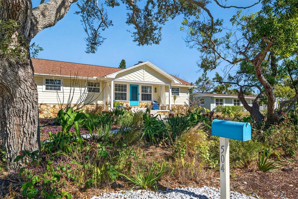 A light yellow house with a blue front door and a matching blue mailbox — 504 BAYVIEW PARKWAY, NOKOMIS, FL