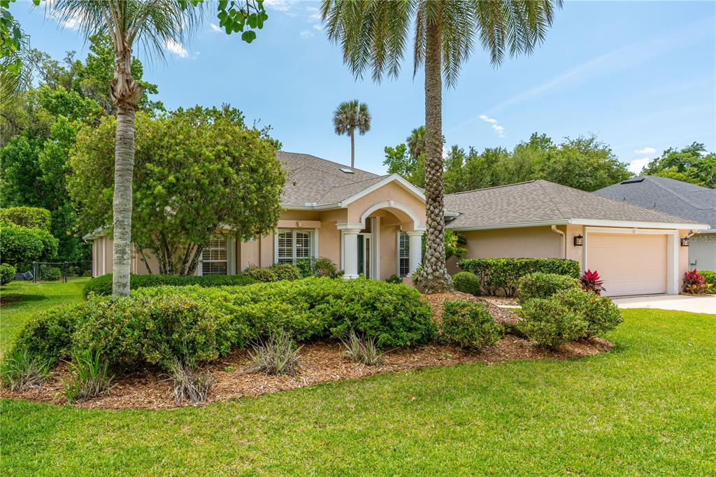 A single-story house with a beige exterior, a two-car garage, and a landscaped front yard — 12 JOLYNN DRIVE, ORMOND BEACH, FL