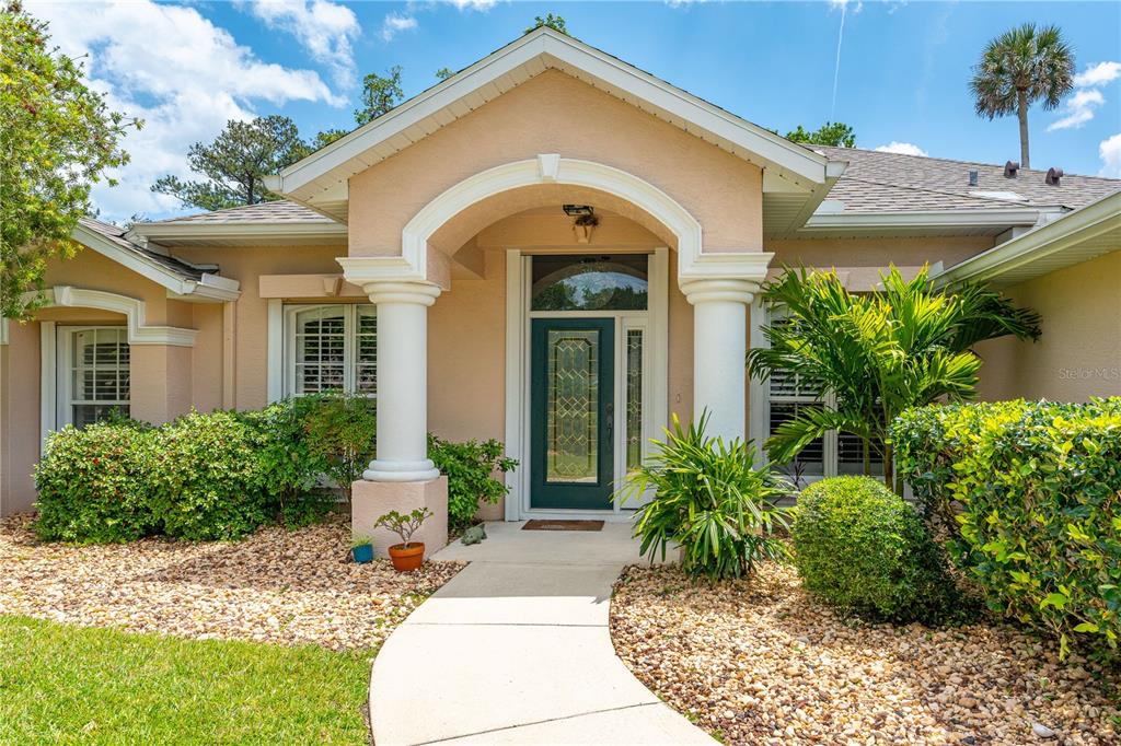 The exterior of a single-story house features a covered entryway with white columns — 12 JOLYNN DRIVE, ORMOND BEACH, FL