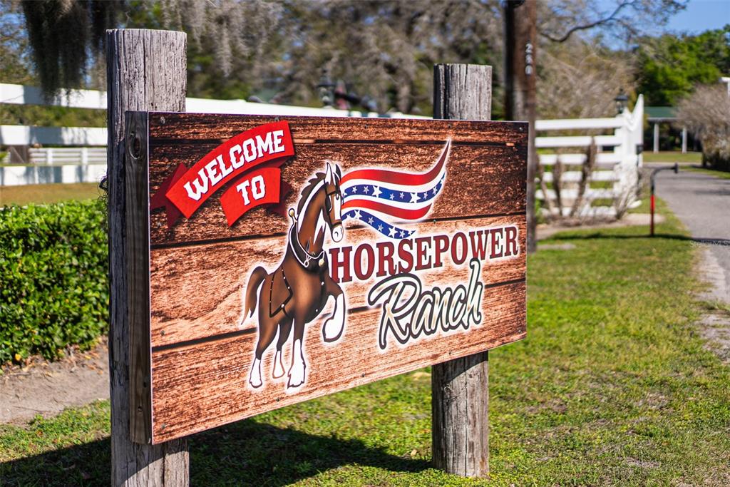 A wooden sign reading Welcome to Horsepower Ranch stands in front of a white fence — 280 CAMPBELL RANCH RUN, GENEVA, FL