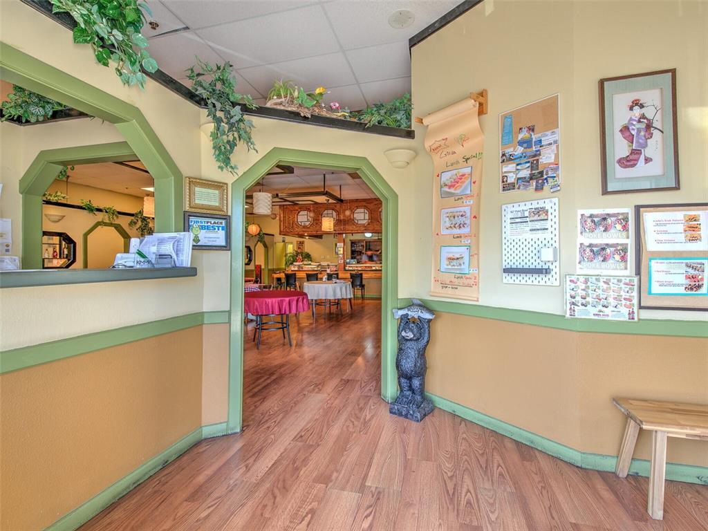 The interior of a restaurant features a wooden floor, arched doorways, and wall-mounted menu displays — 2215 COLLIER PARKWAY, LAND O LAKES, FL