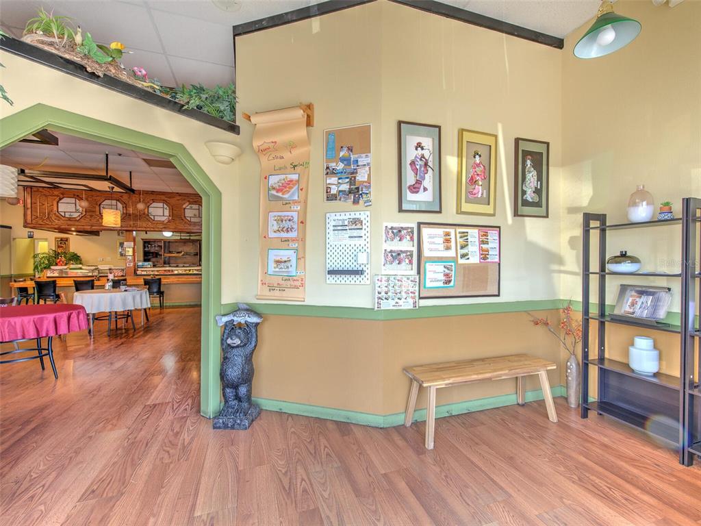 A restaurant interior features a wooden bench, a bear statue, and framed wall art — 2215 COLLIER PARKWAY, LAND O LAKES, FL